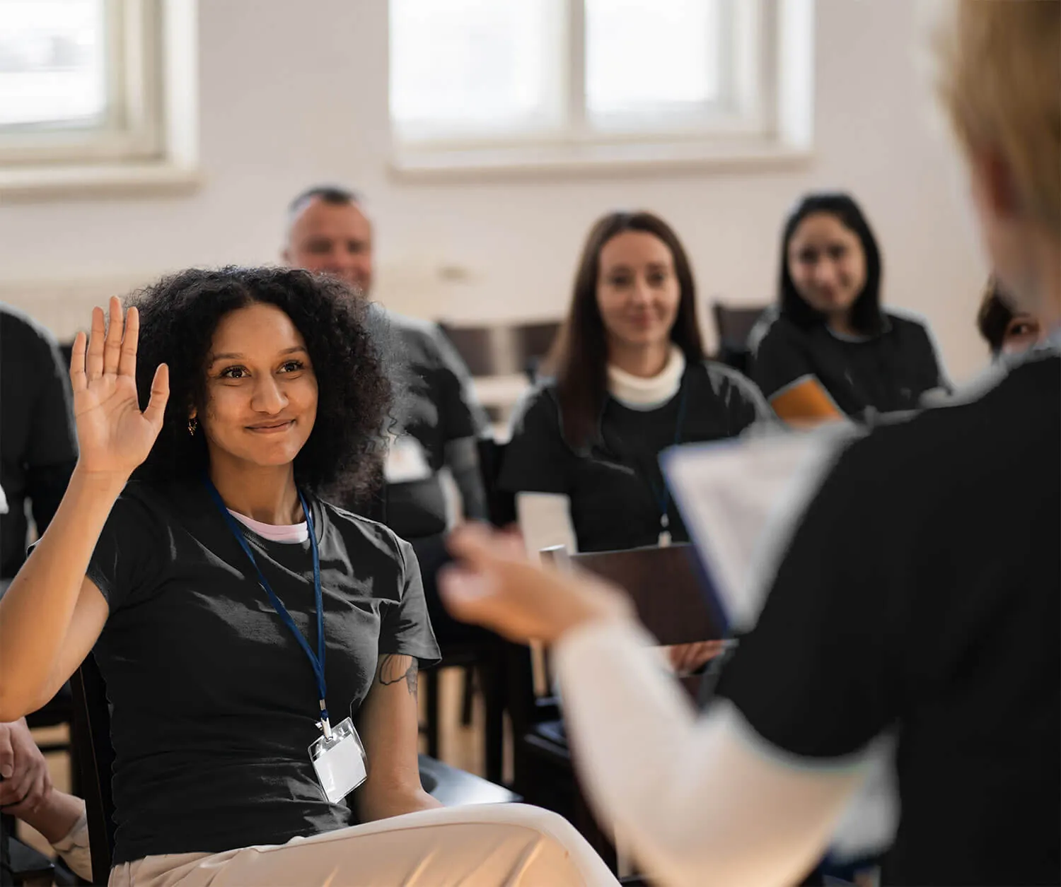 A massage therapy student raising her hand in class