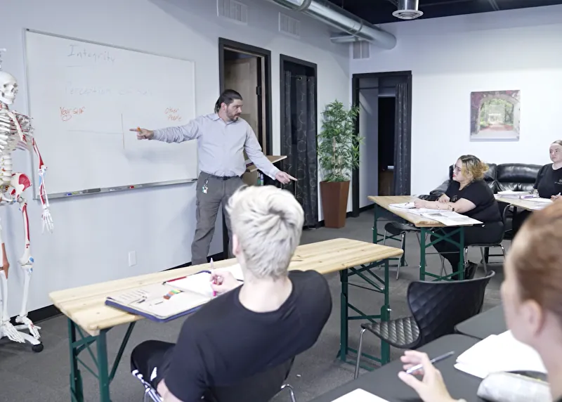 An instructor teaching massage therapy students in the classroom